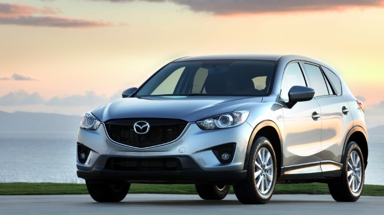 Silver 2014 Mazda CX-5 parked on a road at sunset.