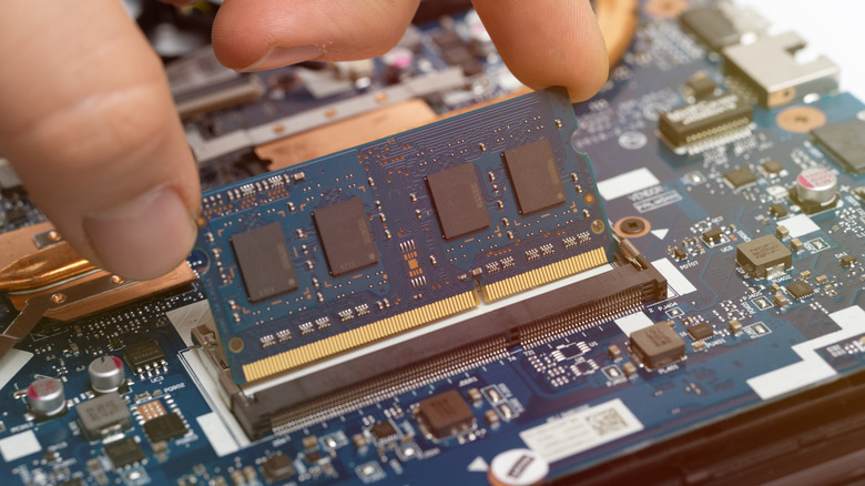 Close up of person installing laptop memory