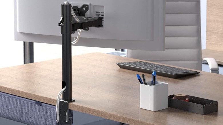 A monitor stand attached to a monitor and desktop