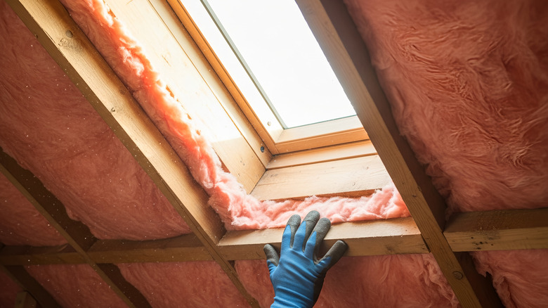 Insulation being installed near attic window.