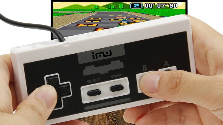 Person holding controller in front of monitor