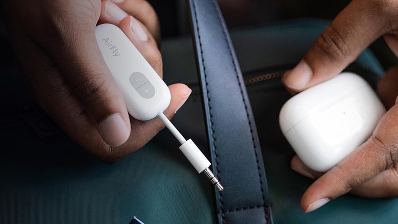 Airfly Bluetooth transmitter held in hand.