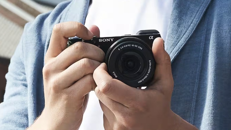 A person holding a Sony Alpha a600.