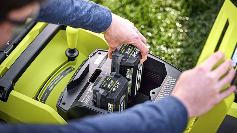 Person installing Ryobi battery pack into a power tool