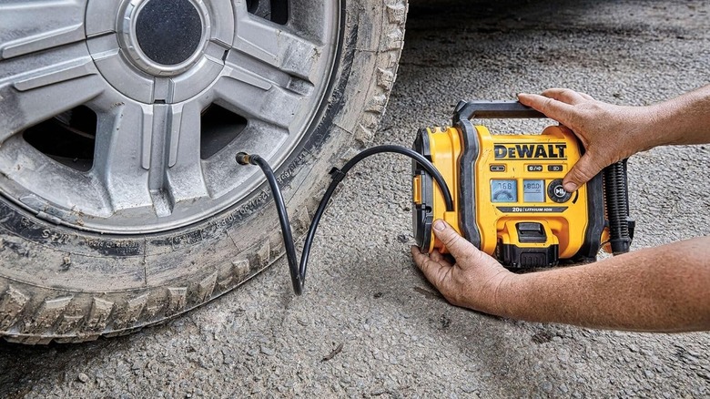 Using a DeWalt portable inflator to inflate a car tire