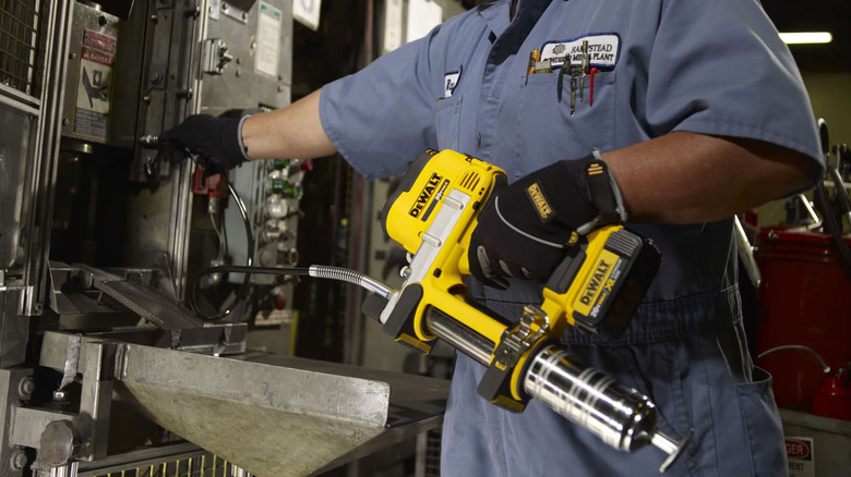 Worker using a DeWalt 20V Max grease gun.