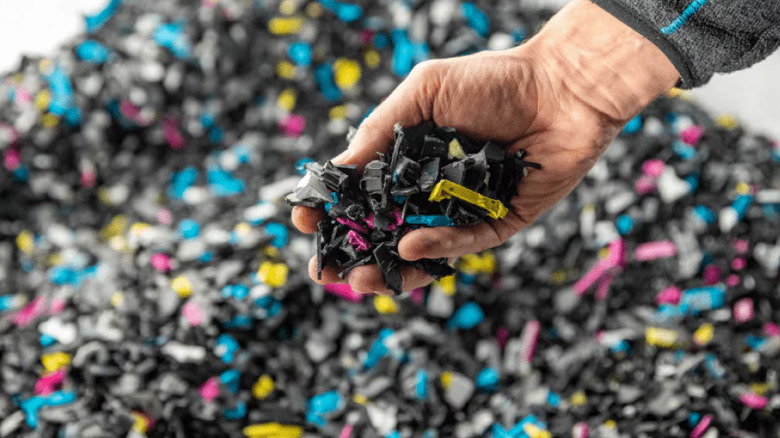 Hand holding HP ink cartridges at a recycling facility in Thurnau, Germany.