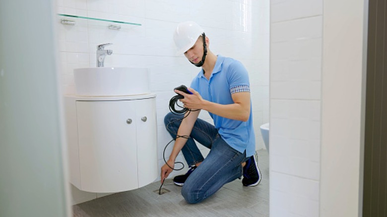 Man using inspection camera to check drain