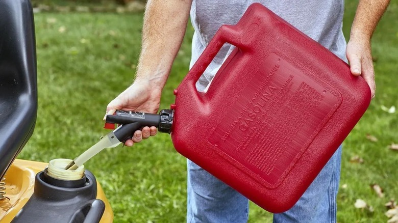 Person using Garage Boss Five Gallon Gas Can to fill a car.