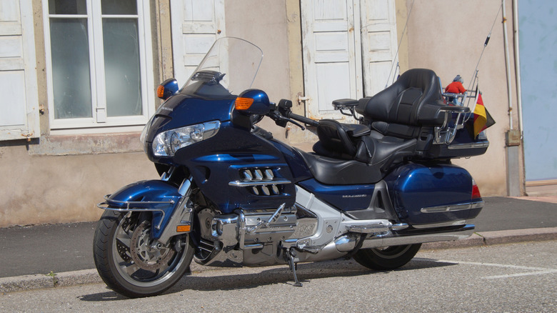 A dark-blue Honda Gold wing parked next to some buildings in the city of La Petit-Pierre.