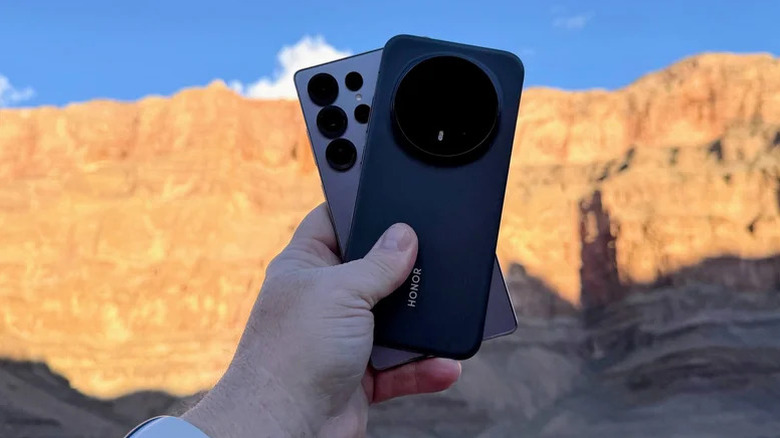 Hand holding Samsung Galaxy S25 Ultra and Honor Magic8 Pro at Grand Canyon