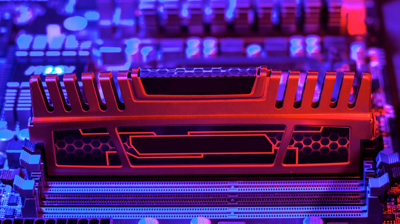 Close up of a RAM module inserted into a PC motherboard.