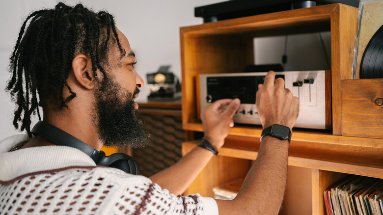 man adjusting amp at home
