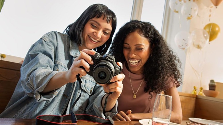 Two people clicking pictures using a Canon camera