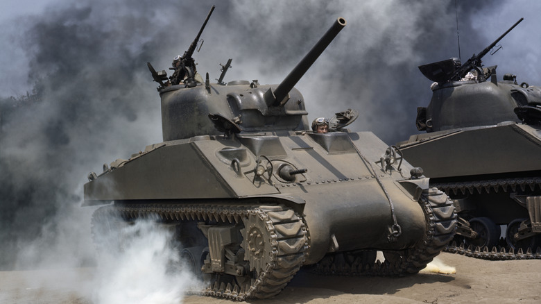 M4 Sherman tanks as they maneuver through smoke during a training exercise