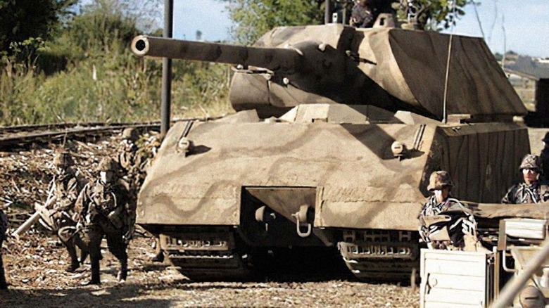 Soldiers standing beside a Super Heavy Super Massive Panzer VIII Maus tank