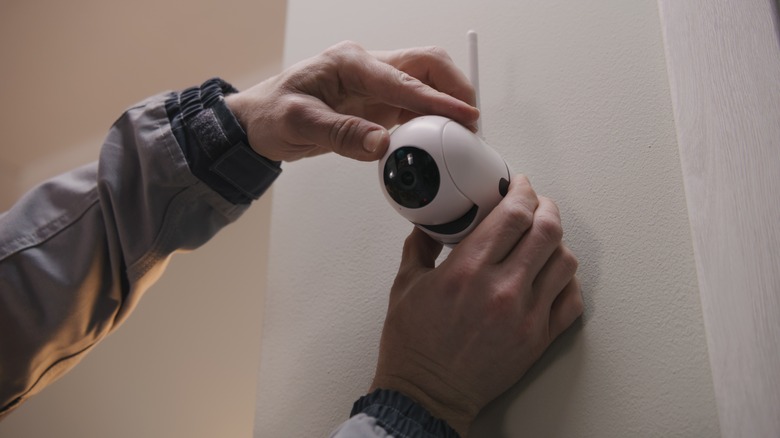 A man installing a wireless security camera