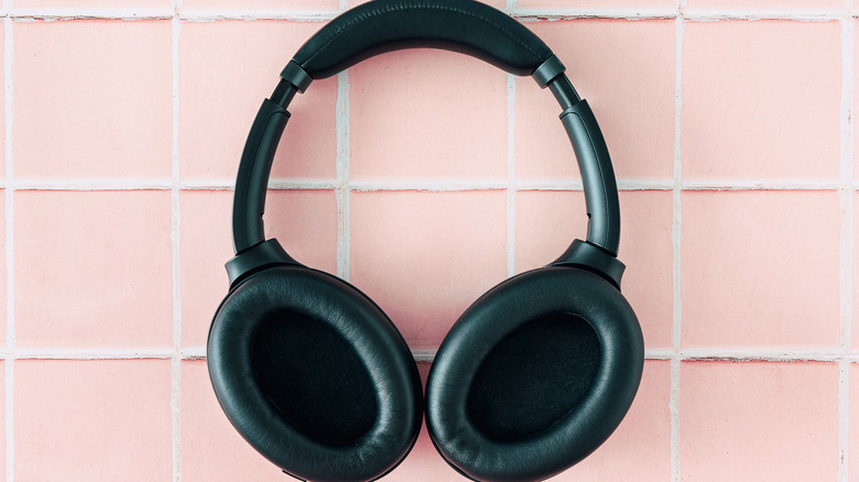 Black headphones on pink tiles.