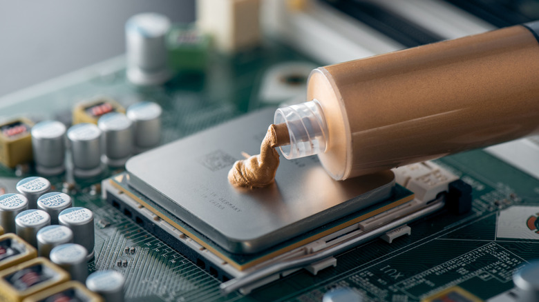 Gold thermal paste being applied to a processor
