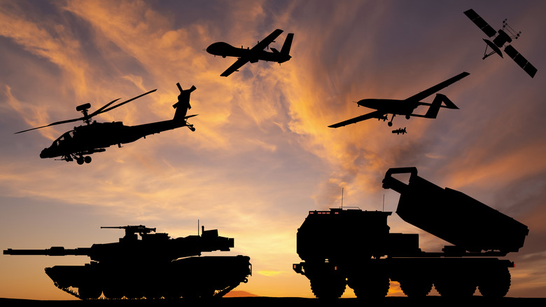 Military ground vehicles and aircraft in silhouette.