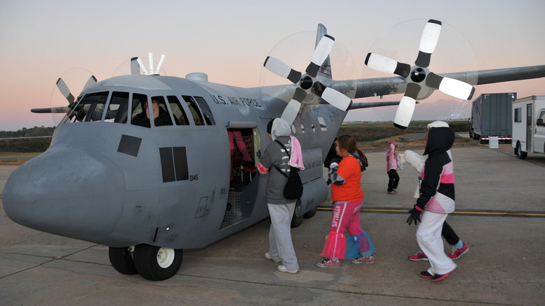 A group of people board the Mini C-130.