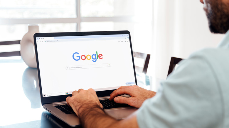 A man using the Google search engine on his laptop.