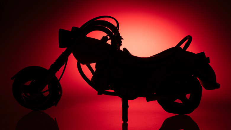 Silhouette of a motorcycle in red lighting