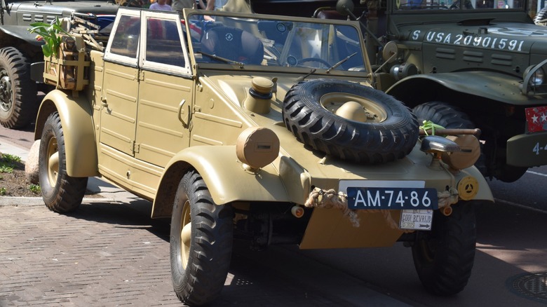 A restored dunkelgelb (field yellow) Kübelwagen Type 82 on display at a car show.
