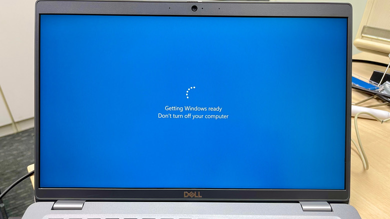 Dell laptop screen show Windows update progress.