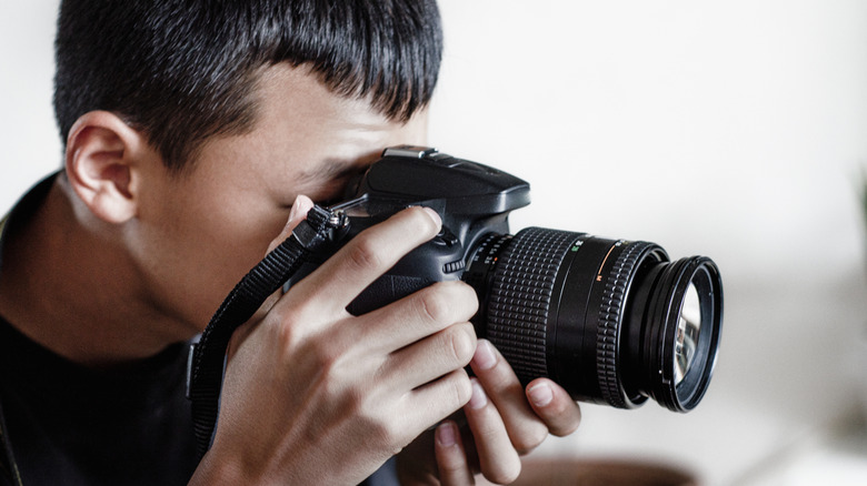 A person holding a DSLR camera.