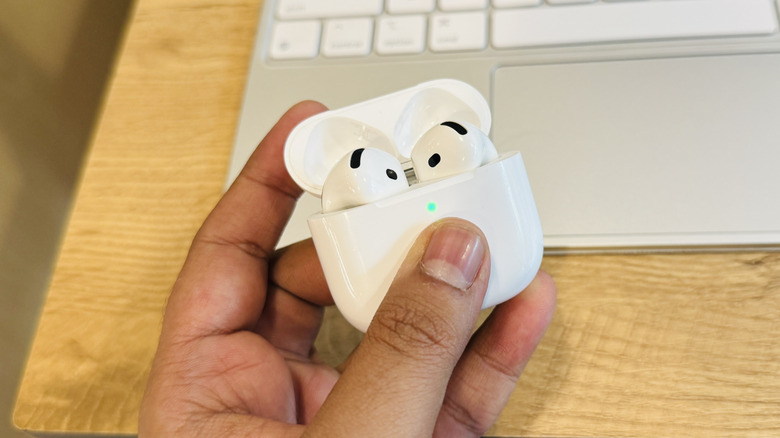 Thumb pressing capacitive button on AirPods 4