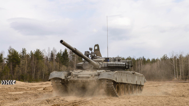 A T-72 tank on dusty ground.
