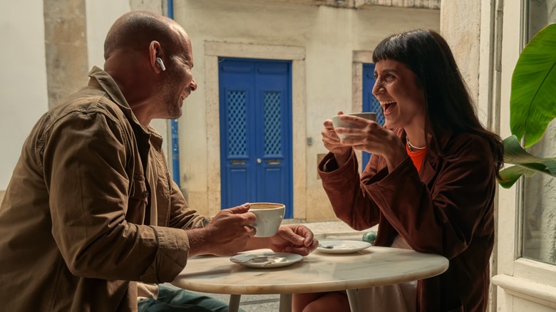 Two people with AirPods using Live Translation