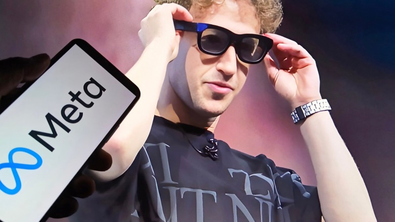 Mark Zuckerberg wearing Meta AI glasses at Meta Connect 2025 with someone holding a Meta wallpaper phone