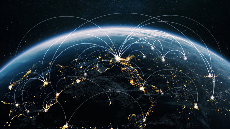 A night-time shot of the Earth from space showing internet connections joining up countries.