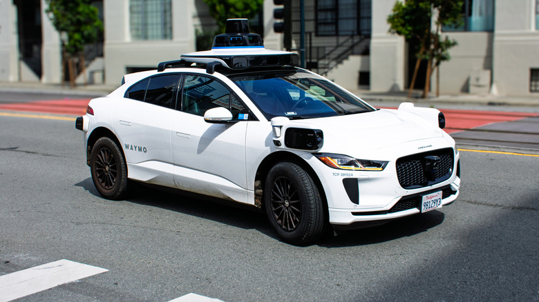 A Waymo Jaguar I-Pace taxi on the road in San Francisco, front 3/4 view