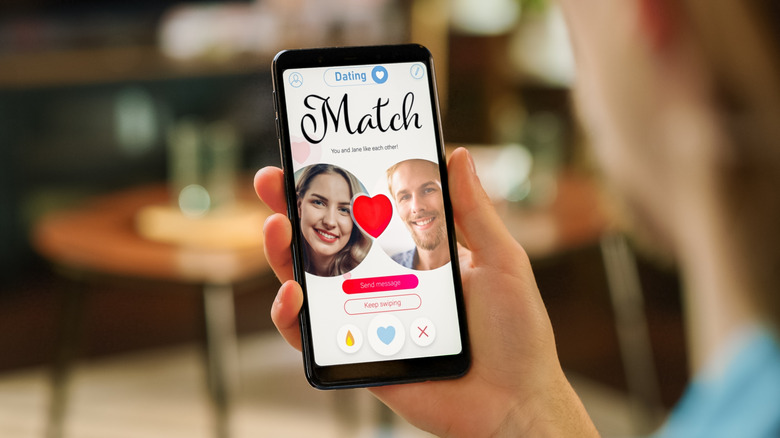 Smartphone held in hand, showing a dating app concept.