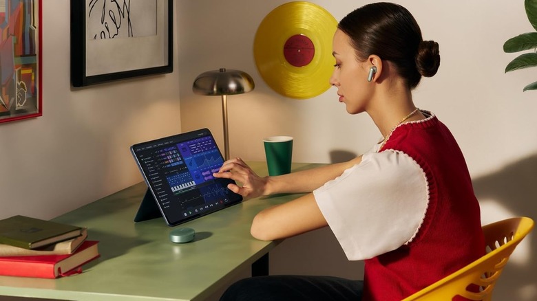 A person using a OnePlus Pad 3 on a desk.