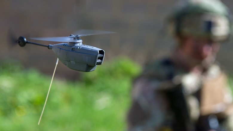 A Teledyne FLIR Black Hornet Nano in flight being operated by a soldier