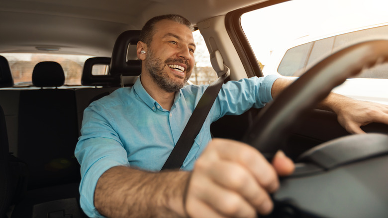 A man using earbuds while driving