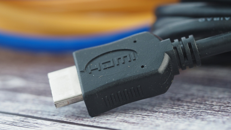 An HDMI cable on top of a table with other colorful cables