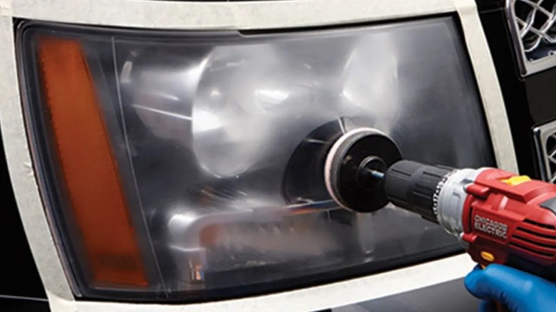 person using lens renewal kit on headlight