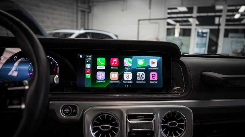 An interior of a Mercedes G-Class showcasing Apple CarPlay on its central screen.