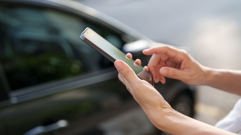 Person using a phone to unlock a car