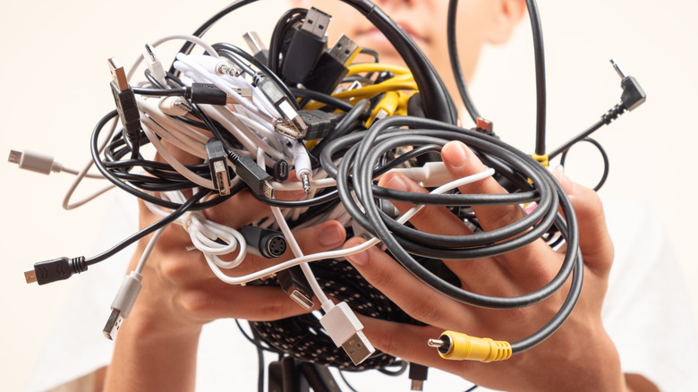 Person holding various tangled cords