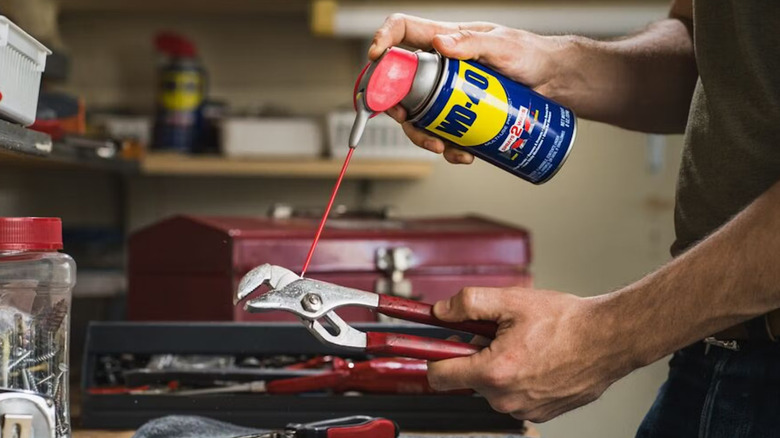 A man using WD-40 on hand tools