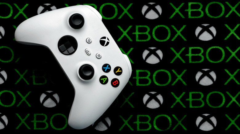 Top view of Xbox white gaming wireless controller over the Xbox logo