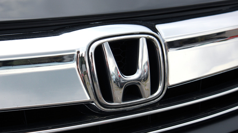 close-up of chrome Honda H logo on front grille of car