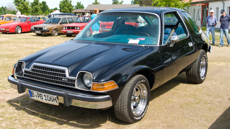 Black AMC Pacer parked on grass in car show setting