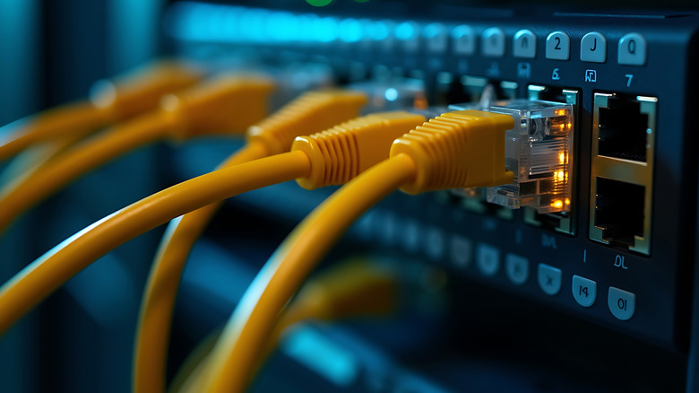 Close up of a network switch with multiple yellow ethernet cables connected for data transfer